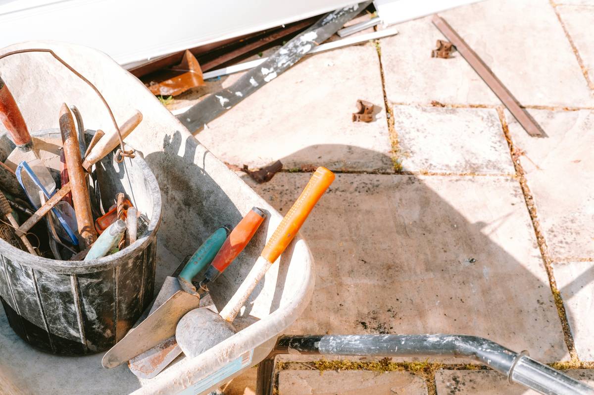 Close-up of a heavy duty caulk gun release lever on a professional-grade tool showing metal construction and ergonomic design