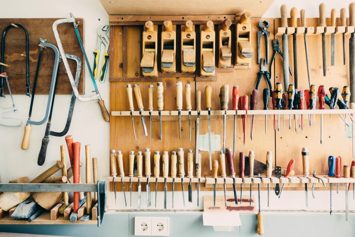 Simple diy caulk gun holder using repurposed ceramic mug under kitchen shelf